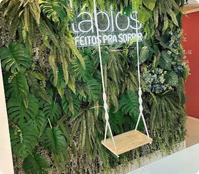 Parede de plantas da Lábios com balanço e a frase feitos pra sorrir