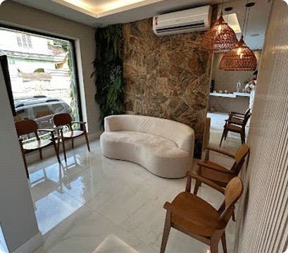 Sala de espera da Lábios com sofá curvo e parede de pedra natural